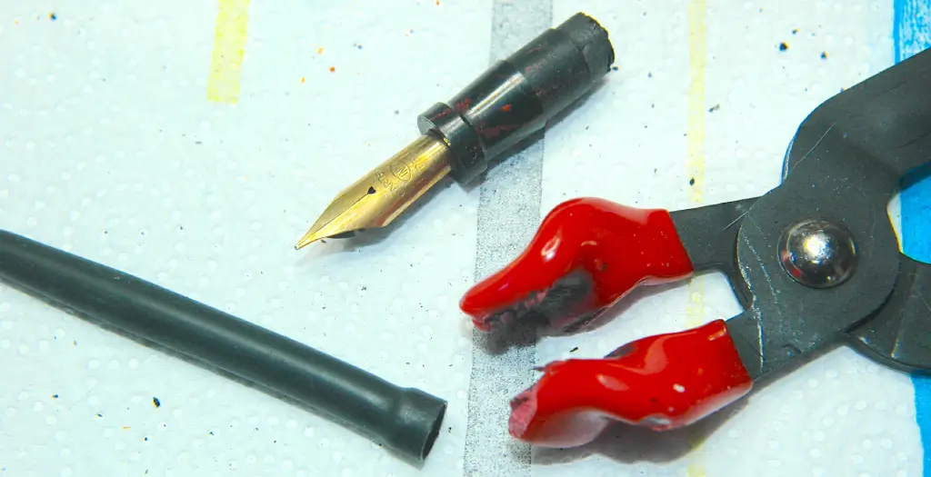 Fountain pen nib, grip section, and pliers.